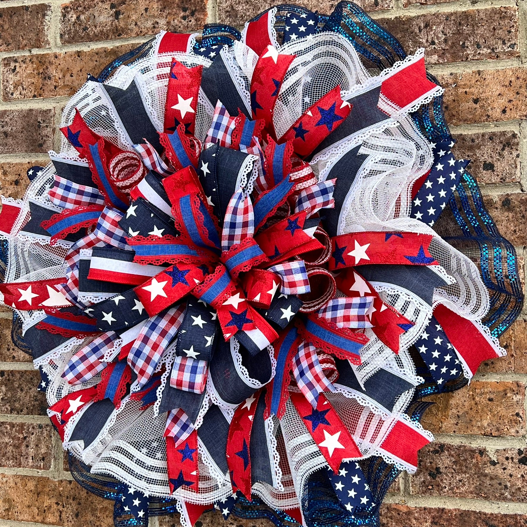 Queen Ann Patriotic Wreath – Star-Spangled Summer Beauty Decorative wreath with American flag patterns on a brick wall background